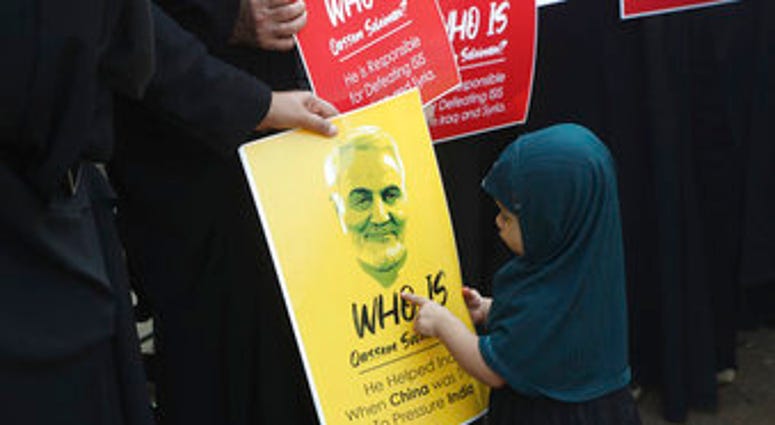 An Indian Shiite Muslim girl points at a portrait of Iranian Gen. Qassem Soleimani who was killed in a U.S. attack, during a protest against the U.S. in Mumbai, India, Thursday, Jan. 9, 2020. (AP Photo/Rafiq Maqbool) An Indian Shiite Muslim girl points at a portrait of Iranian Gen. Qassem Soleimani who was killed in a U.S. attack, during a protest against the U.S. in Mumbai, India, Thursday, Jan. 9, 2020. (AP Photo/Rafiq Maqbool)