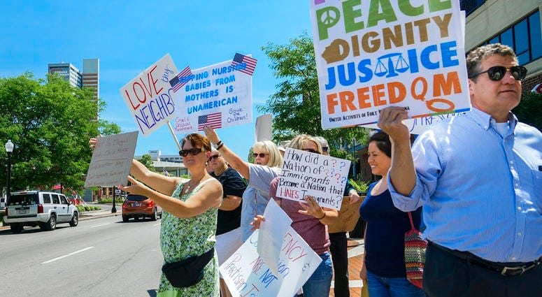 People line up to protest U.S. Attorney General Jeff Sessions and immigration reform at Parkview Field in Fort Wayne, Ind. Thursday, June 14, 2018. (Mike Moore/The Journal-Gazette via AP)