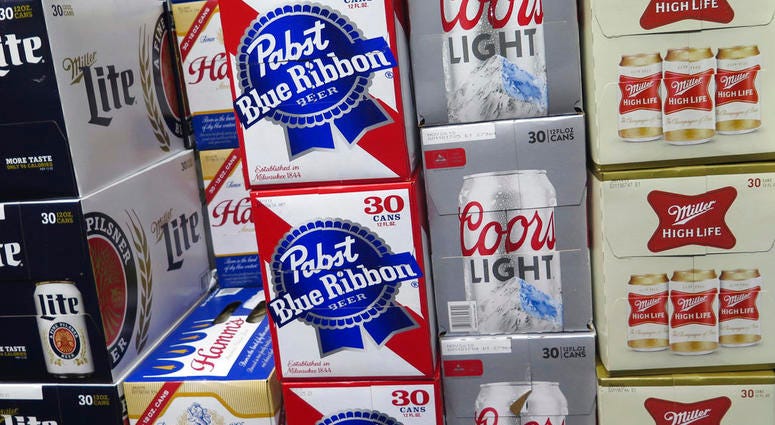 In this photo taken on Thursday, Nov. 8, 2018, cases of Pabst Blue Ribbon and Coors Light are stacked next to each other in a Milwaukee liquor store.