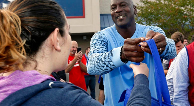 harlotte Hornets owner Michael Jordan greets people and hands out food for Thanksgiving to members of the community in Wilmington, N.C., Tuesday, Nov. 20, 2018.