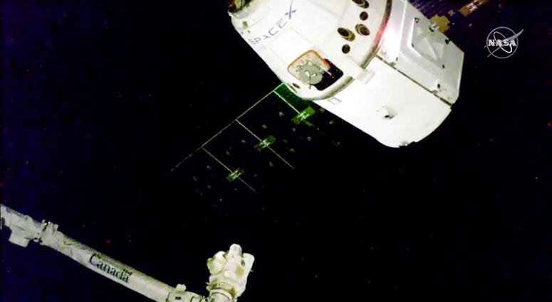 In this image taken from NASA Television, the SpaceX Dragon cargo spacecraft approaches the robotic arm for docking to the International Space Station, Saturday, Dec. 8, 2018.