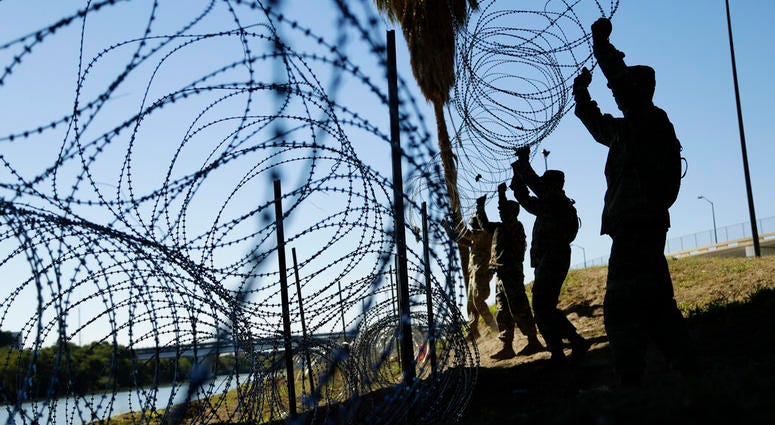 In this Friday, Nov. 16, 2018, file photo, members of the U.S. military install multiple tiers of concertina wire along the banks of the Rio Grande near the Juarez-Lincoln Bridge at the U.S.-Mexico border,