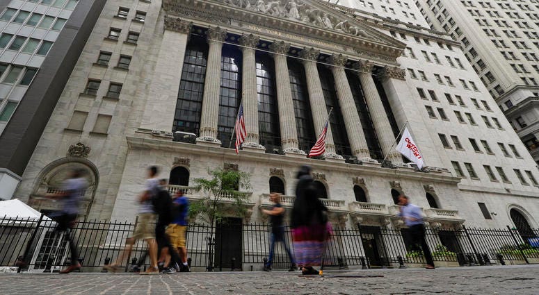 FILE - In this Aug. 23, 2019, file photo pedestrians pass the New York Stock Exchange in New York. Global stock markets were mostly lower Tuesday, Sept. 3, amid revived jitters over U.S.-Chinese trade tension, while wrangling by British lawmakers over whe