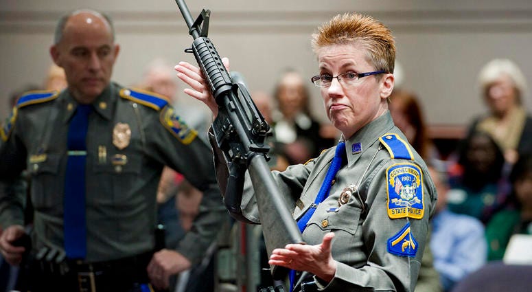 FILE - In this Jan. 28, 2013, file photo, firearms training unit Det. Barbara J. Mattson, of the Connecticut State Police, holds up a Bushmaster AR-15 rifle, the same make and model of gun used by Adam Lanza in the Sandy Hook School shooting, for a demons