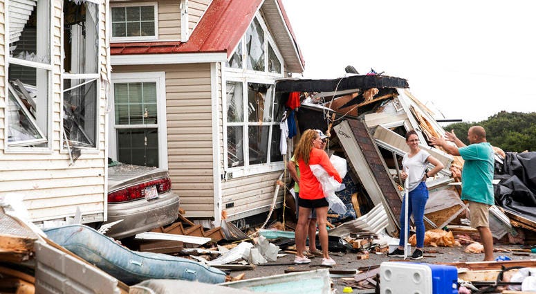 Residents of the Boardwalk RV Park discuss the path of a possible waterspout or tornado, generated by Hurricane Dorian, struck the area, Thursday, Sept. 5, 2019, in Emerald Isle, N.C. (Julia Wall/The News & Observer via AP)