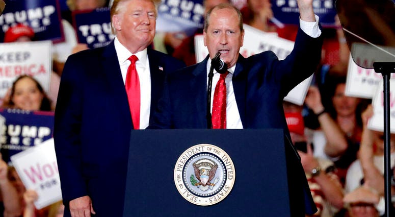 President Donald Trump, left, gives his support to Dan Bishop, right, a Republican running for the special North Carolina 9th District U.S. Congressional race as he speaks at a rally in Fayetteville, N.C., Monday, Sept. 9, 2019. (AP Photo/Chris Seward)