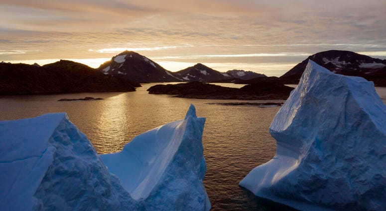 This early Friday, Aug. 16, 2019 file photo shows an aerial view of large Icebergs floating as the sun rises near Kulusuk, Greenland. (AP Photo/Felipe Dana)