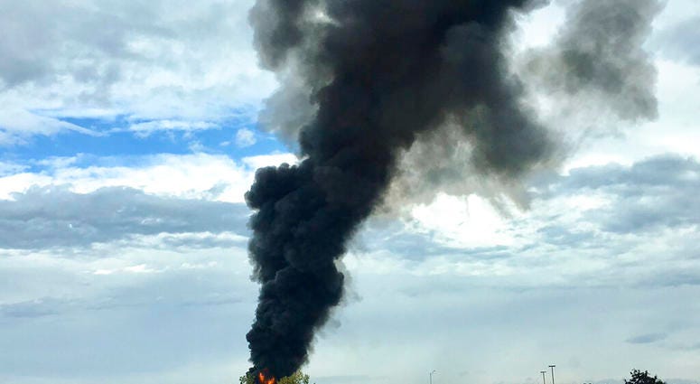 In this photo provided by Antonio Arreguin, smoke fills the sky after a World War II-era bomber plane crashed, Wednesday, Oct. 2, 2019 outside Bradley International Airport north of Hartford, Conn. (Antonio Arreguin via AP)