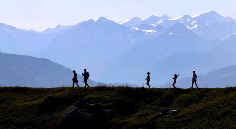People make their way from the 'Kitzbuehler Horn' mountain (1,996 meters) at the alps near Kitzbuehl, Austria, Sunday, Oct. 27, 2019.(AP Photo/Matthias Schrader)