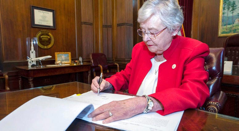FILE-In this Wednesday, May 15, 2019 file photo released by the state shows Alabama Gov. Kay Ivey signing a bill that virtually outlaws abortion in the state, in Montgomery, Ala.