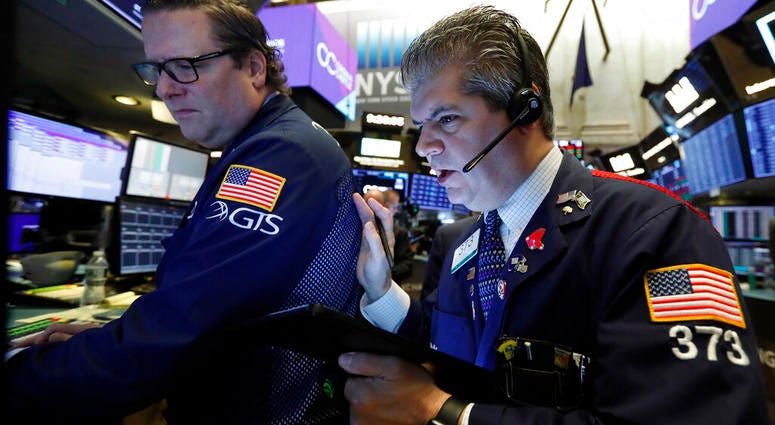 In this Tuesday, Oct. 29, 2019, file photo specialist Gregg Maloney, left, and trader John Panin work on the floor of the New York Stock Exchange. (AP Photo/Richard Drew, File)
