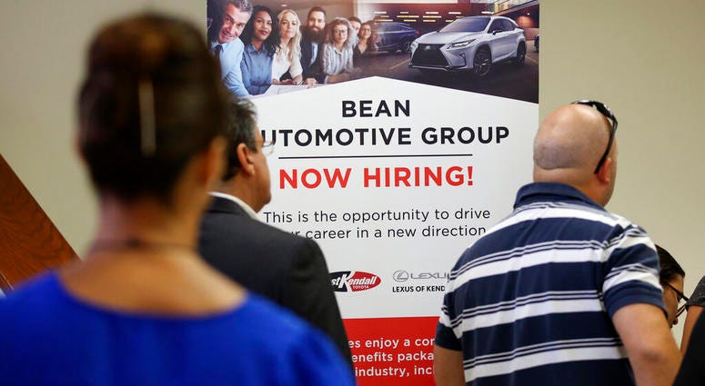 FILE - In this Sept. 18, 2019, file photo people stand in line to inquire about jobs available at the Bean Automotive Group during a job fair in Miami. On Friday, Jan. 10, 2020, the U.S. government issues the December jobs report. (