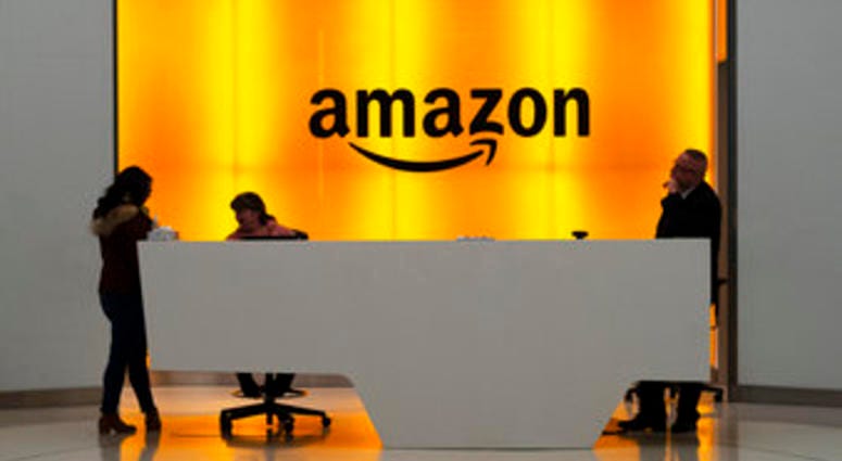 FILE - In this Feb. 14 file photo people stand in the lobby for Amazon offices in New York. Amazon says President Trump's “improper pressure" harmed its chances of winning a $10 billion Pentagon contract. (AP Photo/Mark Lennihan, File) FILE - In this Feb. 14 file photo people stand in the lobby for Amazon offices in New York. Amazon says President Trump's “improper pressure" harmed its chances of winning a $10 billion Pentagon contract. (AP Photo/Mark Lennihan, File)