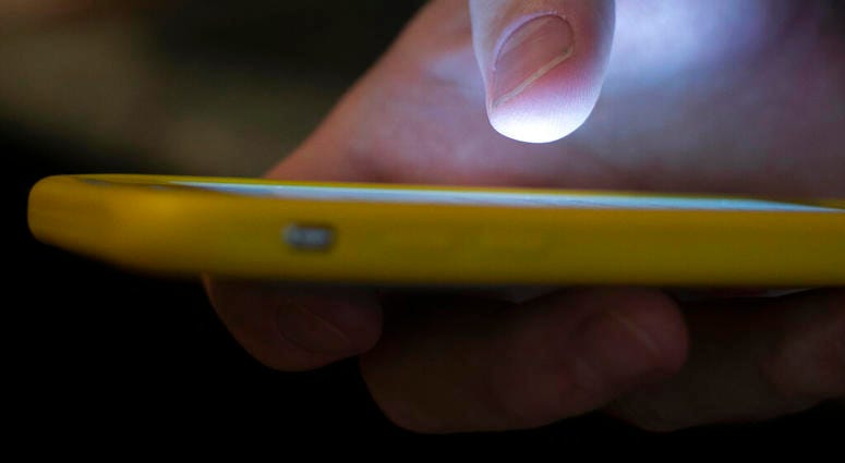 FILE - In this Aug. 11, 2019, file photo, a man uses a cell phone. The Federal Communications Commission is setting up a new three-digit number to reach a suicide prevention hotline. (AP Photo/Jenny Kane, File) FILE - In this Aug. 11, 2019, file photo, a man uses a cell phone. The Federal Communications Commission is setting up a new three-digit number to reach a suicide prevention hotline. (AP Photo/Jenny Kane, File)