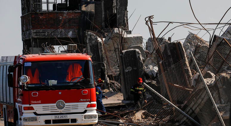 Firefighters search for trapped people at a damaged structure following an earthquake at the port of Piraeus, near Athens, on Friday, July 19, 2019. (AP Photo/Petros Giannakouris)