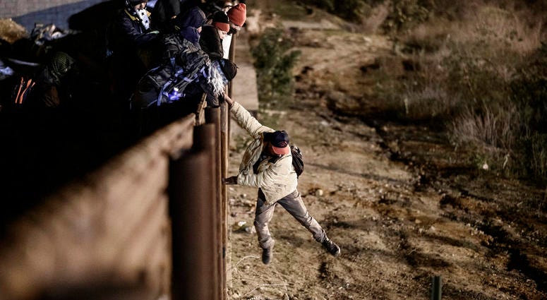 A migrant jumps the border fence to get into the U.S. side to San Diego, Calif., from Tijuana, Mexico, Tuesday, Jan. 1, 2019. (AP Photo/Daniel Ochoa de Olza)