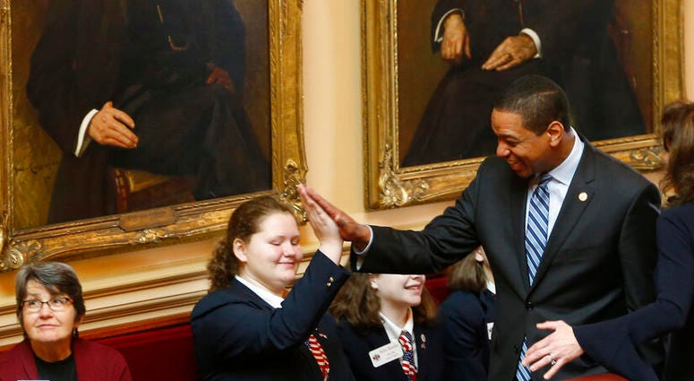 Virginia Lt. Gov. Justin Fairfax, right, gives a high five to a page as he prepares for the start of the Senate session at the Capitol in Richmond, Va., Friday, Feb. 8, 2019. (AP Photo/Steve Helber)