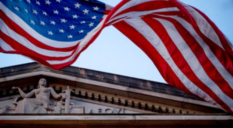 FILE - In this March 22, 2019 file photo, an American flag flies outside the Department of Justice in Washington. (AP Photo/Andrew Harnik)