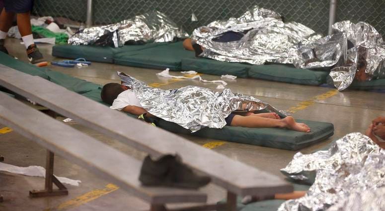 FILE - In this June 18, 2014, file photo, young boys sleep in a holding cell where hundreds of mostly Central American immigrant children are being processed and held at the U.S. Customs and Border Protection Nogales Placement Center in Nogales, Ariz. CPB