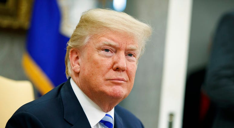 File - In this May 16, 2018, file photo, President Donald Trump listens to a question during a meeting in the Oval Office of the White House in Washington. Trump says he'll demand that the Justice Department review whether it or the FBI infiltrated his ca