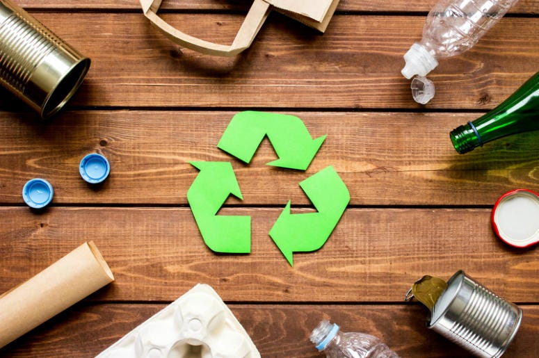Eco concept with recycling symbol and garbage on wooden table background top view Eco concept with recycling symbol and garbage on wooden table background top view