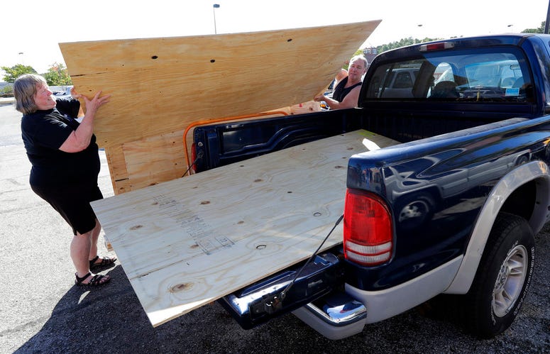 Mickey Manes, right, and Diane Manes, left, load plywood into their truck in advance of Hurricane Florence in Wilmington, N.C., Wednesday, Sept. 12, 2018. Florence exploded into a potentially catastrophic hurricane Monday as it closed in on North and Sout Mickey Manes, right, and Diane Manes, left, load plywood into their truck in advance of Hurricane Florence in Wilmington, N.C., Wednesday, Sept. 12, 2018. Florence exploded into a potentially catastrophic hurricane Monday as it closed in on North and Sout