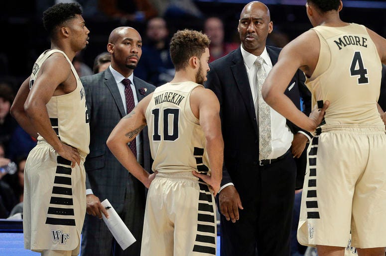 Wake Forest assistant coach Jamill Jones, second from left, with the team and head coach Danny Manning, second from right, during the second half of an NCAA college basketball game in Winston-Salem, N.C. Police say Jones threw a punch that killed a New Yo Wake Forest assistant coach Jamill Jones