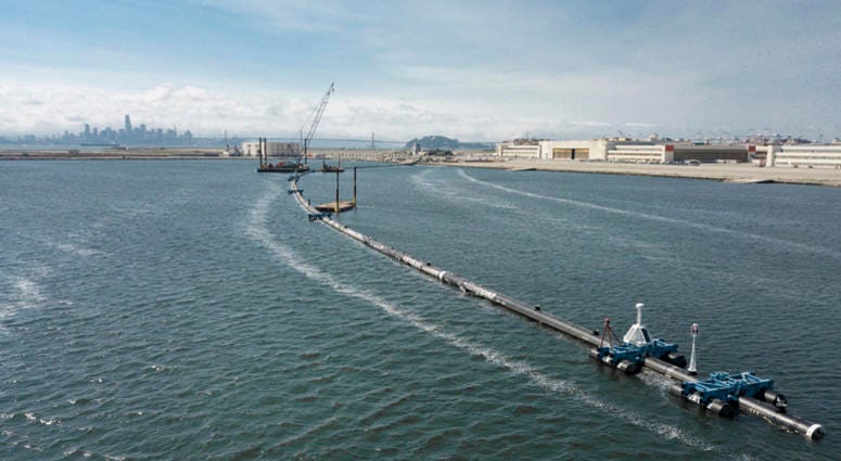 AP18250791823574 In this Monday, Aug. 27, 2018 photo provided by The Ocean Cleanup, a long floating boom that will be used to corral plastic litter in the Pacific Ocean is assembled in Alameda, Calif. Engineers will deploy a trash collection device to corral plastic litte