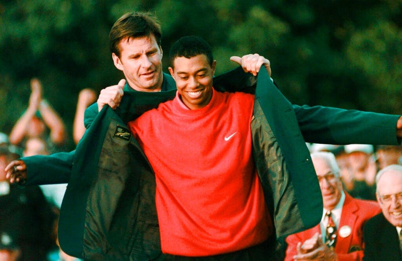 Masters champion Tiger Woods receives his Green Jacket from last year's winner Nick Faldo, rear, at the Augusta National Golf Club in Augusta, Ga. Woods completes an amazing journey by winning the 2019 Masters, overcoming 11 years of personal foibles and