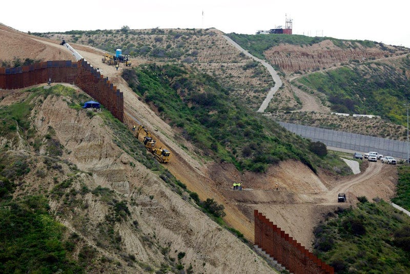 construction crews replace a section of the primary wall separating San Diego