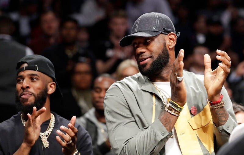 Chris Paul and LeBron James applaud during a ceremony at an NBA basketball game between the Brooklyn Nets and the Miami Heat, Wednesday, April 10, 2019, in New York. The pair were there to watch Heat guard Dwyane Wade play his last NBA game