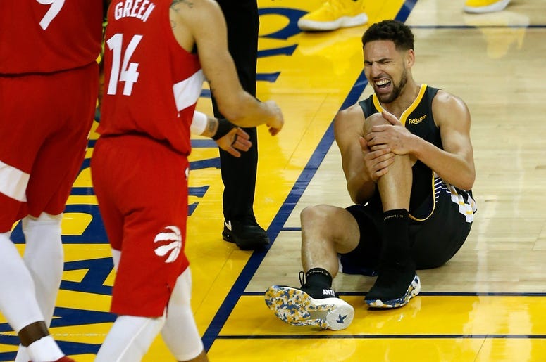 Klay Thompson #11 of the Golden State Warriors reacts after hurting his leg against the Toronto Raptors in the second half during Game Six of the 2019 NBA Finals at ORACLE Arena on June 13, 2019 in Oakland, California. NOTE