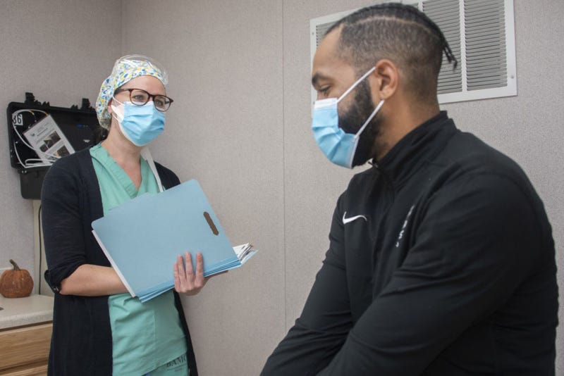 Alfiya Mityukova, a registered nurse, and Roderick Johnson, a research assistant, demonstrate patient screening for the Operation Warp Speed COVID-19 vaccine trial at Brooke Army Medical Center, Fort Sam Houston, Texas, Nov. 16, 2020.