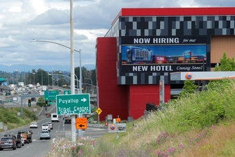 FILE - In this July 9, 2020, file photo, a large video display reads "Now hiring for our new hotel coming soon!," at the new Emerald Queen Casino, which is open, and owned by the Puyallup Tribe of Indians, in Tacoma, Wash. (AP Photo/Ted S. Warren, File)