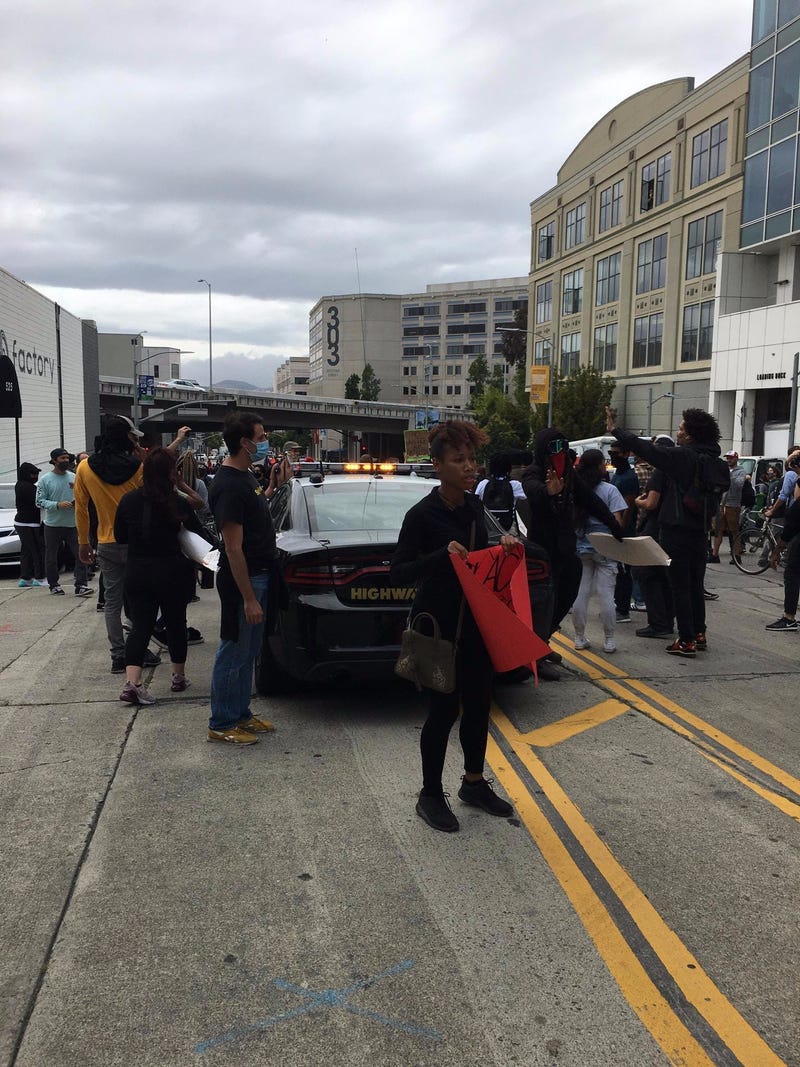 Demonstrators protect a police vehicle at a San Francisco rally.