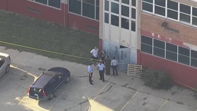 Police gathered outside Roxborough High School, where after a football practice Tuesday, five players were shot. One of them died.