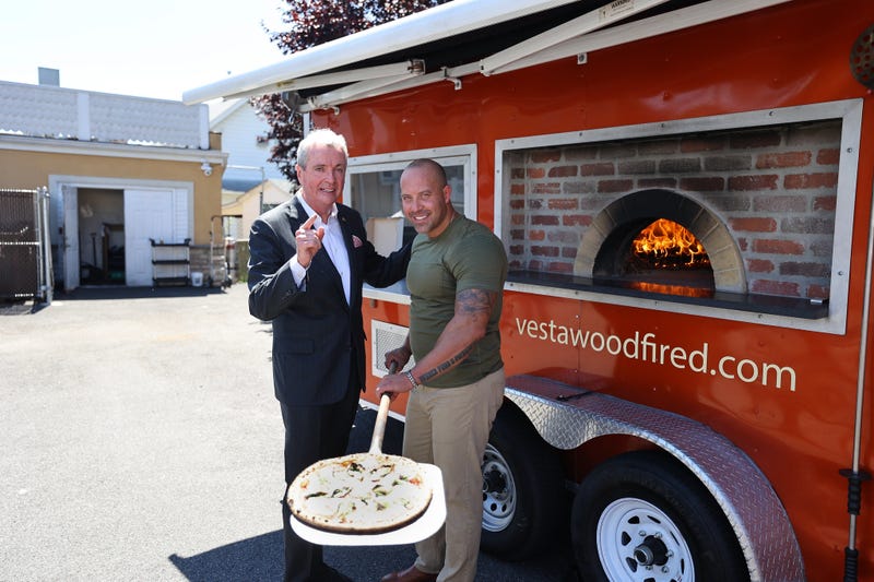 Gov. Phil Murphy (left) stands with a restaurant owner on Aug. 3, 2022, where he announced he signed a bill to extend expanded permissions for restaurants, bars, distilleries, and breweries to use fixtures and equipment enabling them to serve patrons outdoors in private areas, on sidewalks, and in other municipally designated outdoor areas.