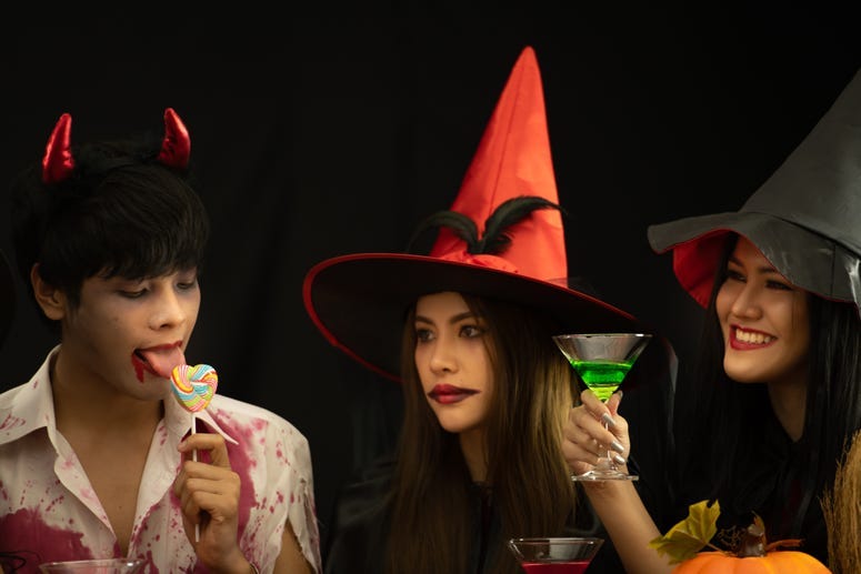 Two witches and a guy licking lollipop