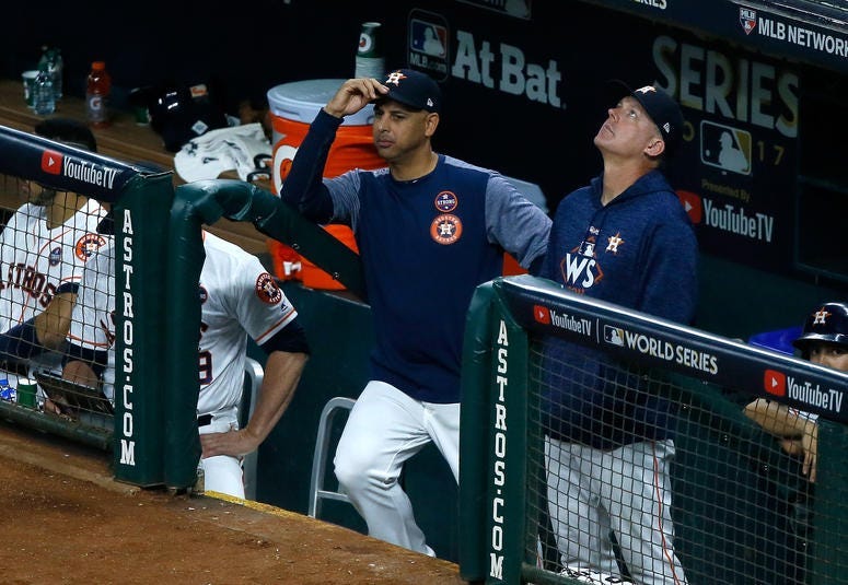 Bench coach Alex Cora and manager A.J. Hinch of the Astros look on from the dugout during the fifth inning against the Los Angeles Dodgers in game five of the 2017 World Series at Minute Maid Park on October 29, 2017 in Houston, Texas.