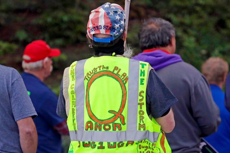 In this May 14, 2020, file photo, a person wears a vest supporting QAnon at a protest rally in Olympia, Wash., against Gov. Jay Inslee and Washington state stay-at-home orders made in efforts to prevent the spread of the coronavirus. President Joe Biden's inauguration has sown a mixture of anger, confusion and disappointment among believers in the baseless QAnon conspiracy theory. (AP Photo/Ted S. Warren, File)