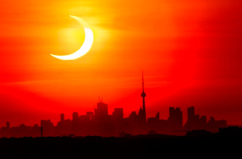 An annular solar eclipse rises over the skyline of Toronto on Thursday, June 10, 2021. (Frank Gunn/The Canadian Press via AP)