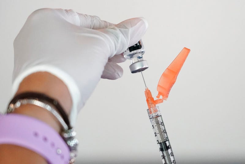A nurse loads a syringe with the Pfizer COVID-19 vaccine