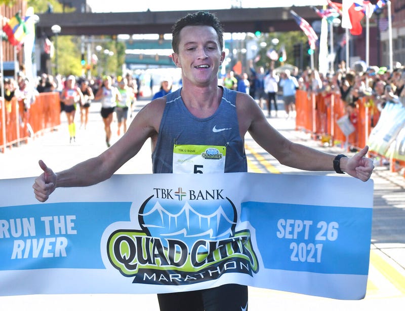 Tyler Pence of Springfield, Ill., finishes first in the TBK Bank Quad Cities Marathon on Sunday, Sept. 26, 2021, in Moline, Ill. An Illinois man unexpectedly won the Quad Cities Marathon this weekend when the two Kenyan runners who had far outpaced him were disqualified after being diverted off the course by a race volunteer bicyclist. Tyler Pence crossed the finish line in 2 hours, 15 minutes, 6 seconds to become the first U.S. runner since 2001 to win the race.