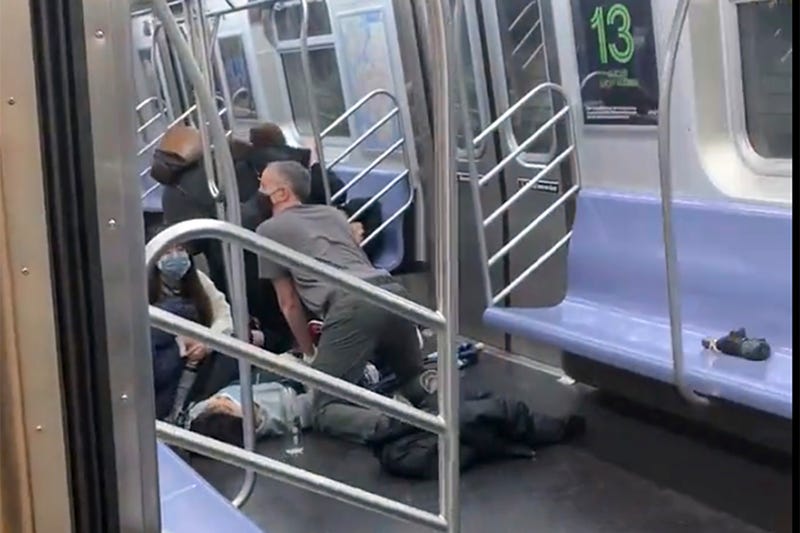 This photo provided by Will B Wylde, a person is aided in a subway car in the Brooklyn borough of New York, Tuesday, April 12, 2022