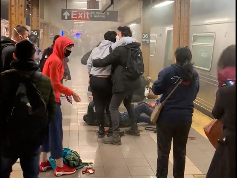 This photo provided by Will B Wylde, a person is aided outside a subway car in the Brooklyn borough of New York, Tuesday, April 12, 2022