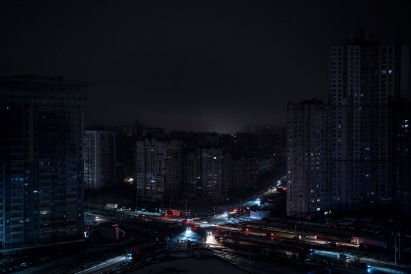 Cars drive past residential blocks which were de-energized after a Russian rocket attack in Kyiv, Ukraine, Wednesday, Nov. 23, 2022.