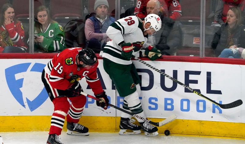 Blackhawks center Jonathan Toews (19) and Minnesota Wild defenseman Dmitry Kulikov (29) battle for the puck.