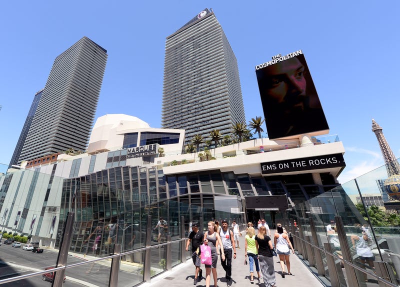 Tourists walk on a pedestrian bridge next to The Cosmopolitan of Las Vegas