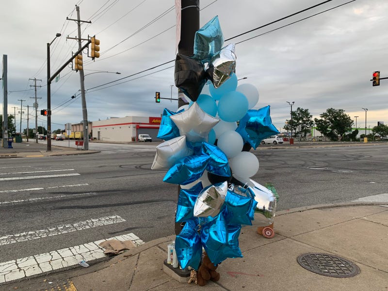 Balloons, candles and stuffed animals adorn a post at Butler Street and Aramingo Avenue in Port Richmond, where a 21-year-old man was shot and killed late Saturday night.
