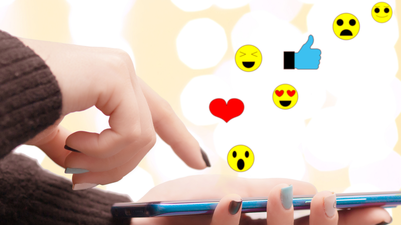 girl holds a phone with flying icons smiles